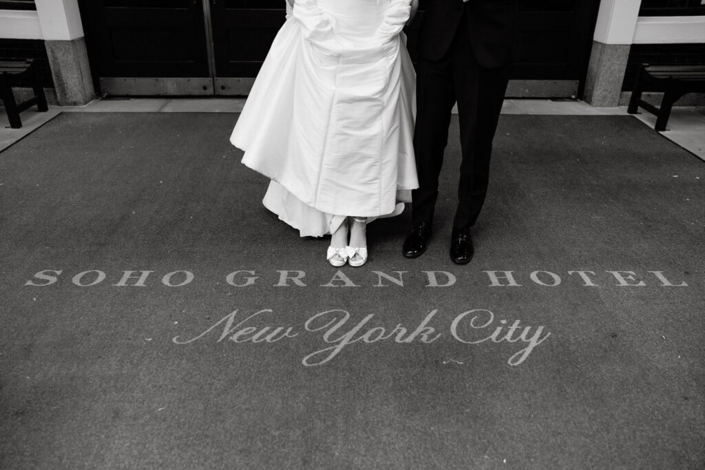Bride and groom standing together on the Soho Grand Hotel entrance mat in New York City