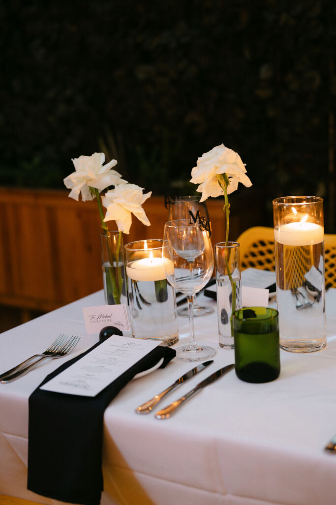 Elegant candlelit wedding reception table with white florals, crystal glassware, and refined place settings at an intimate luxury wedding in New York City.