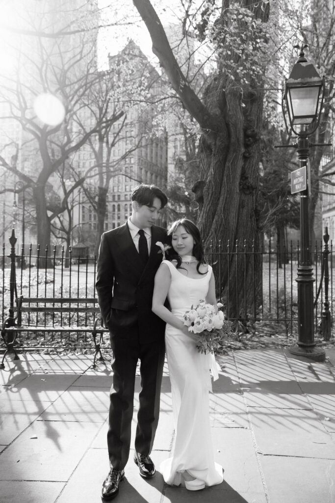 Bride and groom standing together outdoors in soft sunlight