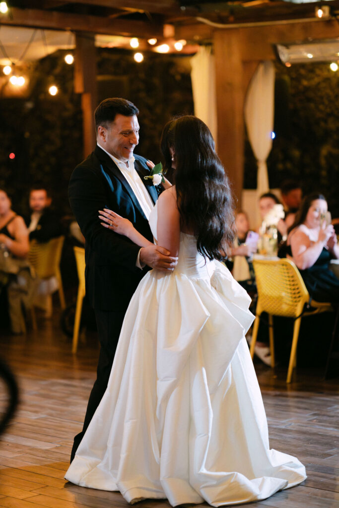 Bride and groom dancing together during a candlelit wedding reception in SoHo, New York City, surrounded by guests and warm evening light.