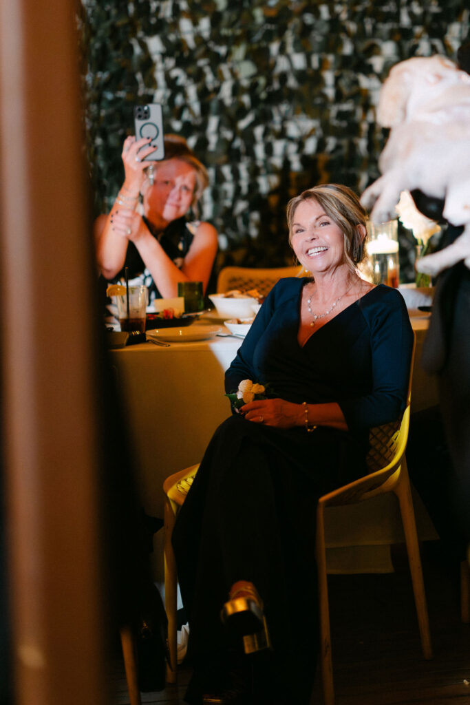 Wedding guest listening and reacting during a heartfelt speech at an intimate candlelit wedding reception in SoHo, New York City.
