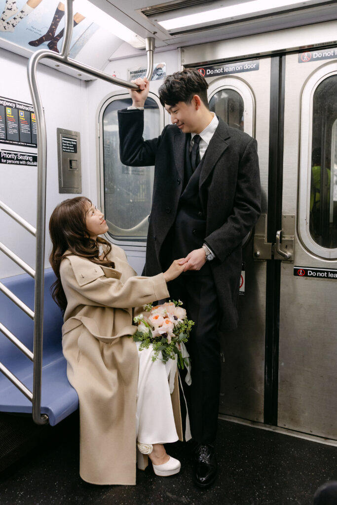 Bride and groom holding hands inside a subway train car