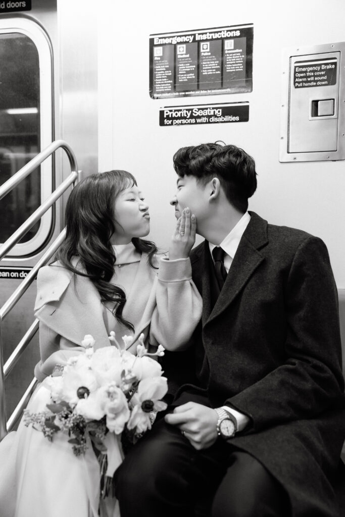 Bride and groom sitting together and looking at each other on a subway train