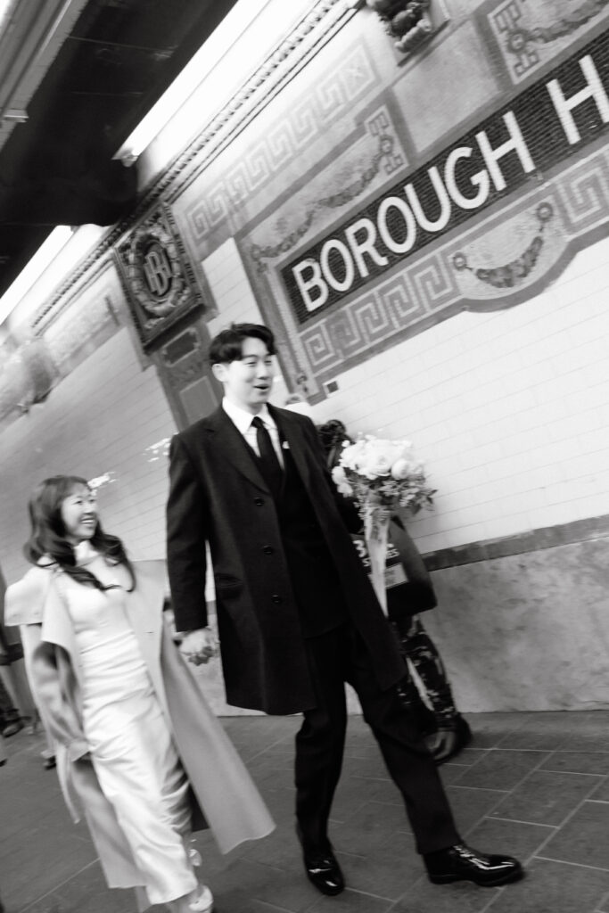 Bride and groom standing on the Borough Hall subway platform in New York City
