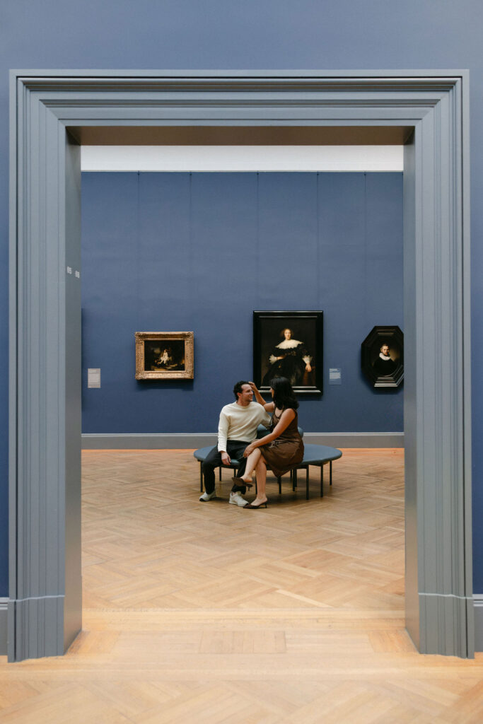 couple sitting together inside an art gallery at the metropolitan museum of art during an nyc engagement session
