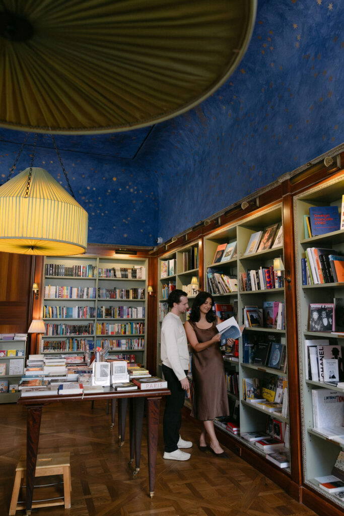 nyc engagement session photo of a couple standing together inside a cozy bookstore on the upper east side