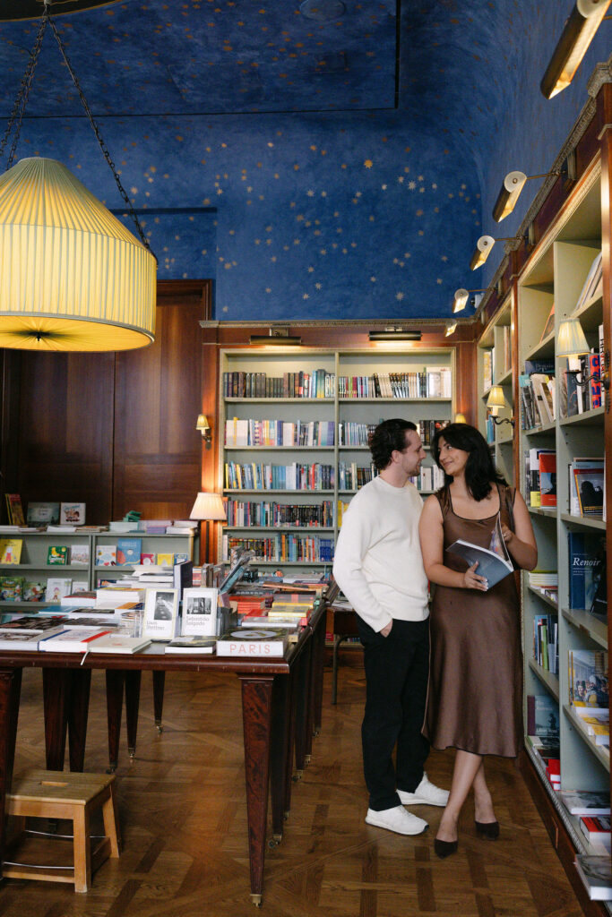 nyc engagement session photo of a couple standing close together inside a bookstore