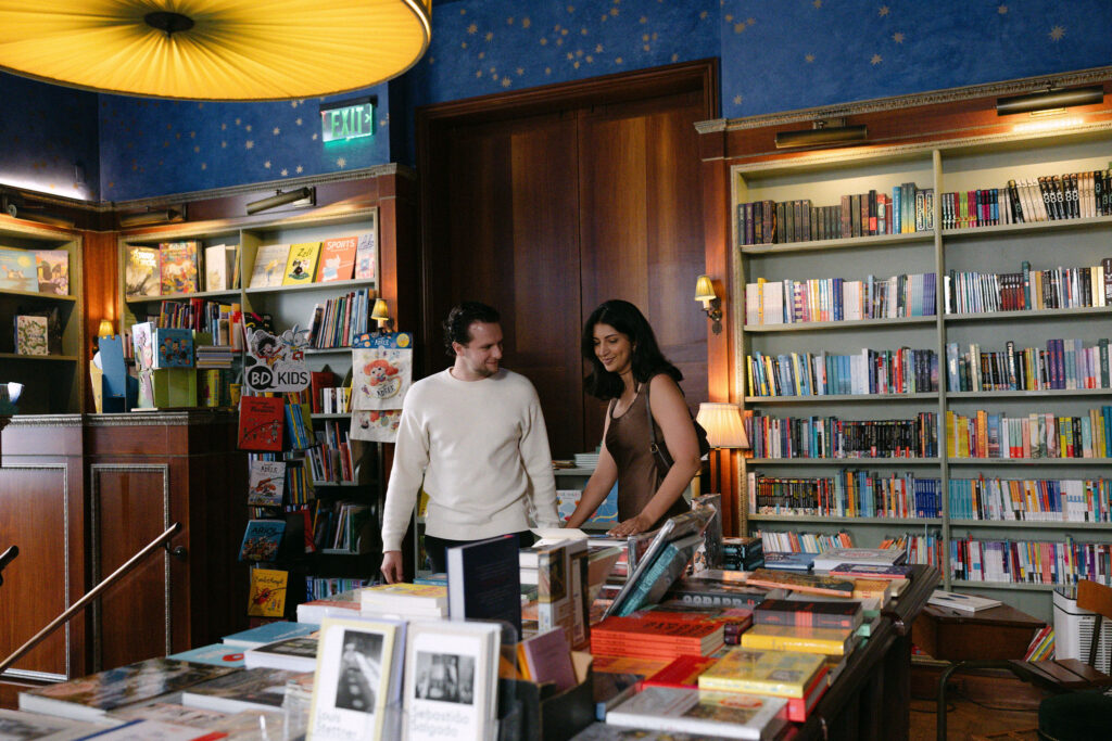 nyc engagement session photo of a couple browsing books together inside a bookstore