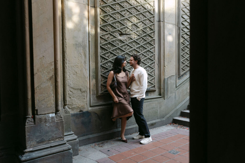 nyc engagement session photo of a couple standing close together on a quiet city street