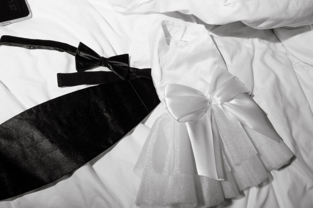 Black and white detail of a wedding dress bow and suit jacket during getting ready at a SoHo wedding in New York City