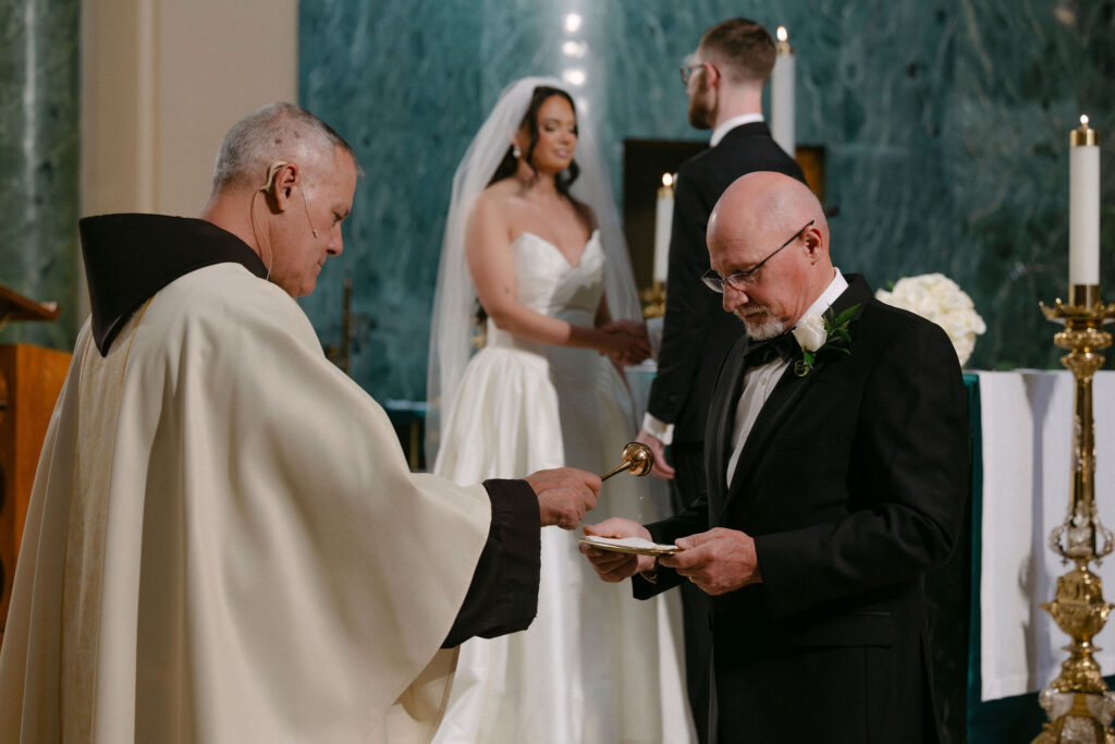 Priest blessing the bride and groom during their wedding ceremony in a SoHo church in New York City