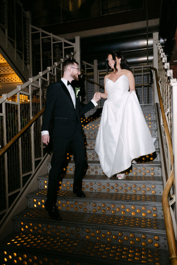 Bride and groom walking down a staircase together after their SoHo wedding in New York City