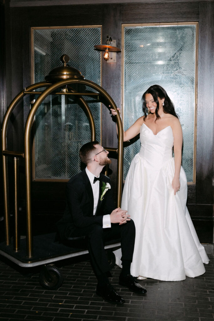 Bride and groom sharing a quiet moment by a hotel luggage cart after their SoHo wedding in New York City