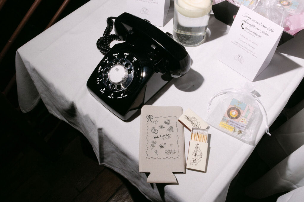 Vintage black rotary phone and handwritten notes displayed as a guest book detail at an intimate wedding reception in SoHo, New York City.