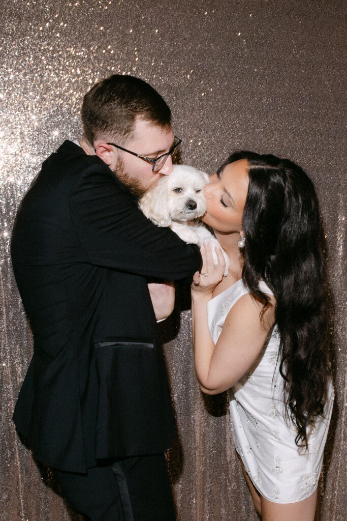 Bride and groom sharing a quiet kiss during a photo booth moment at an intimate wedding reception in SoHo, New York City.