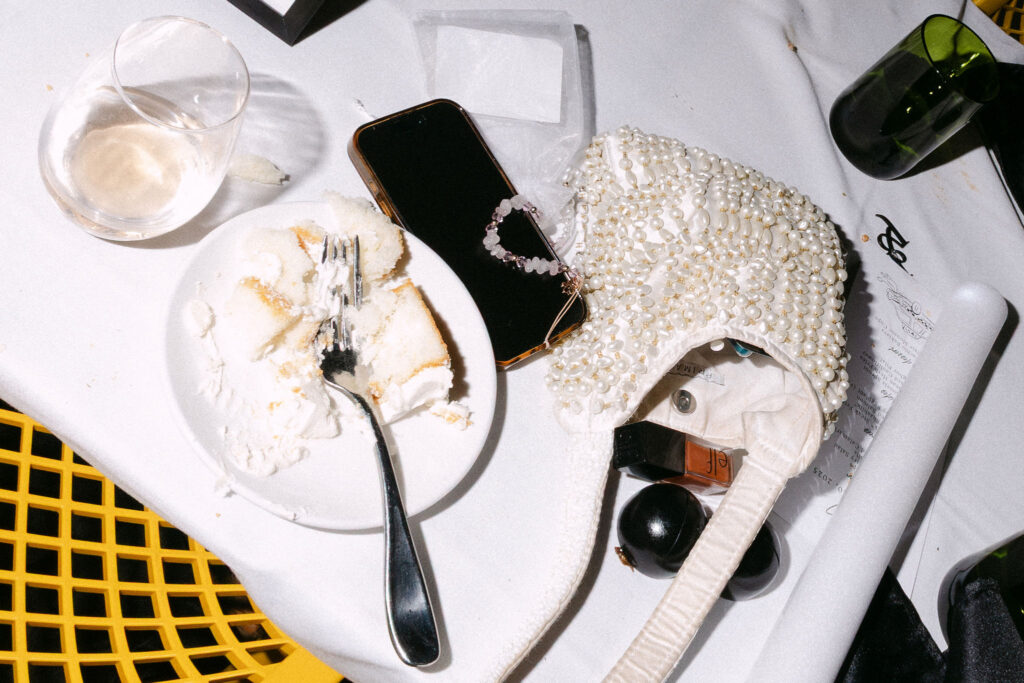 Wedding reception table with empty plates, champagne glasses, and personal items after dinner at an intimate SoHo wedding in New York City.