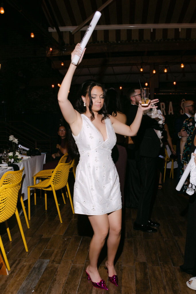 Bride dancing with glow sticks during a lively late-night wedding reception in SoHo, New York City.