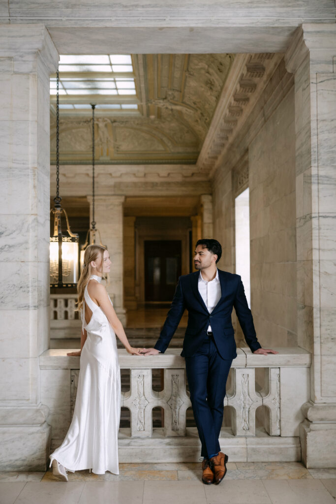 Couple walking inside New York Public Library during elegant NYC engagement session