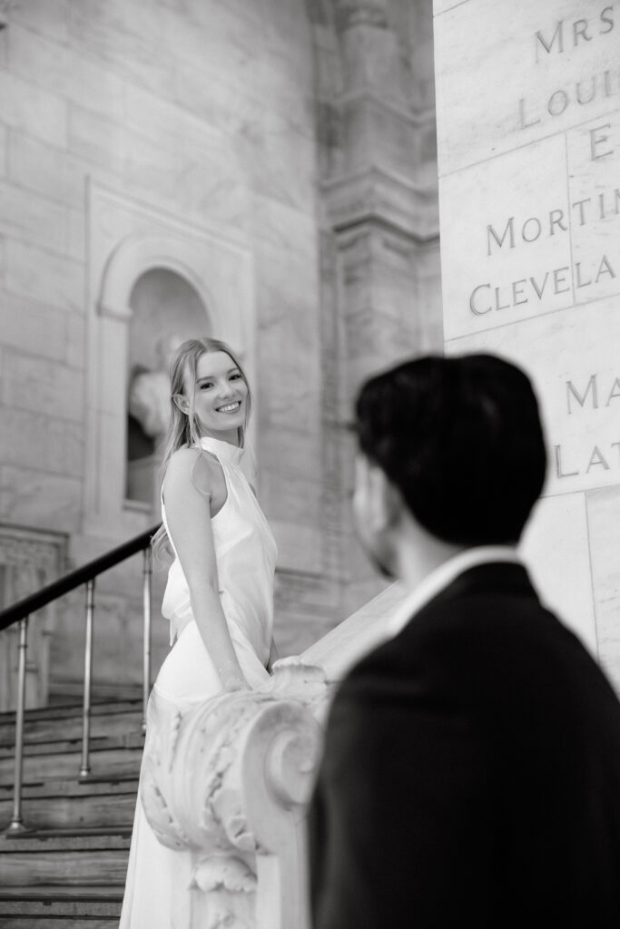 Black and white photo of bride on staircase inside New York Public Library during NYC engagement session