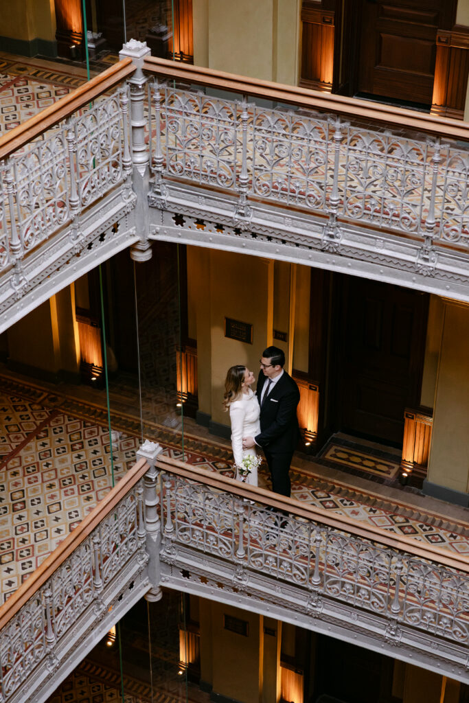 couple standing on upper level beekman hotel nyc wedding elopement before city hall