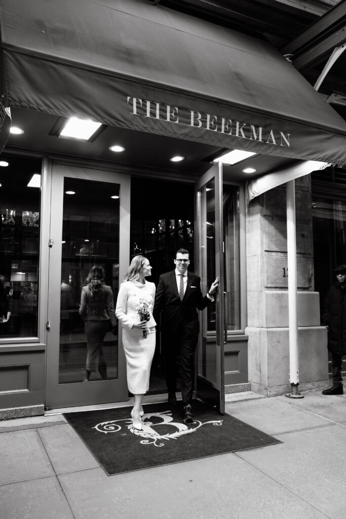 couple outside beekman hotel nyc entrance elopement before city hall wedding black and white