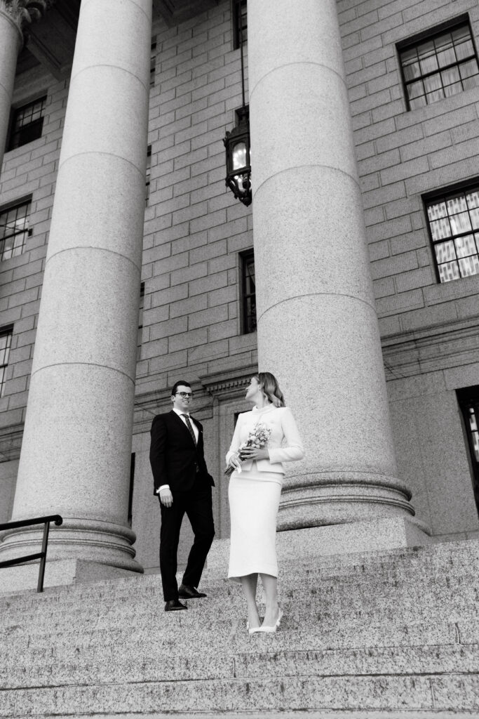 couple outside nyc city hall courthouse columns elopement wedding black and white
