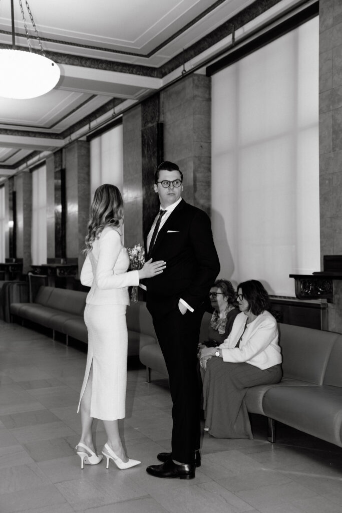 couple talking while waiting at nyc city hall wedding black and white candid moment