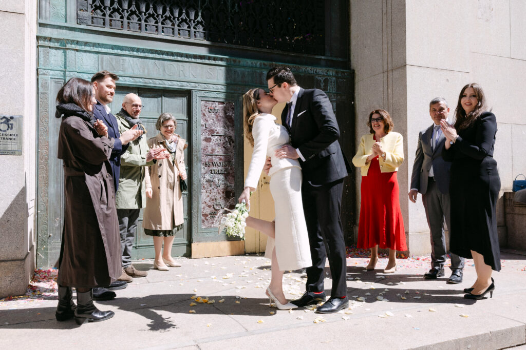 nyc city hall wedding celebration with family and friends just married couple outside