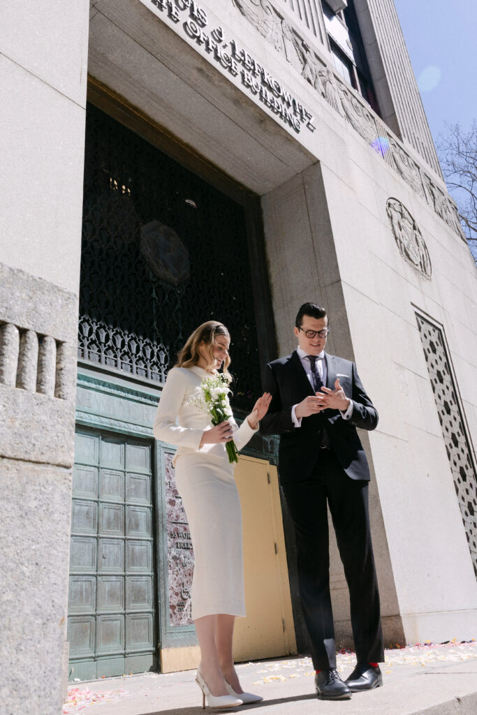 couple outside nyc city hall checking documents after wedding elopement moment