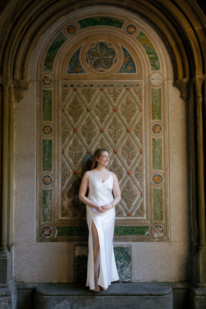 Engaged couple standing beneath the arches at Bethesda Terrace during their Central Park engagement session.