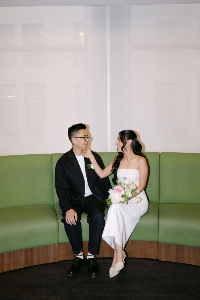 Newlyweds holding a City Hall marriage token beside the bride’s bouquet during their Manhattan City Hall wedding.